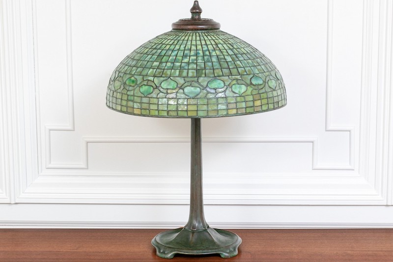 This stunning antique Tiffany Studios bronze four light lamp features a tall Art Nouveau pedestal base with a beautiful patinated finish